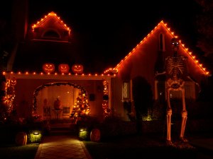A homeowner following the advice of a roofing contractor in Morrisville by regularly checking and securing Halloween decorations.