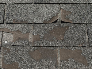 A damaged roof in Garner being inspected by a professional roofer for storm-related issues.